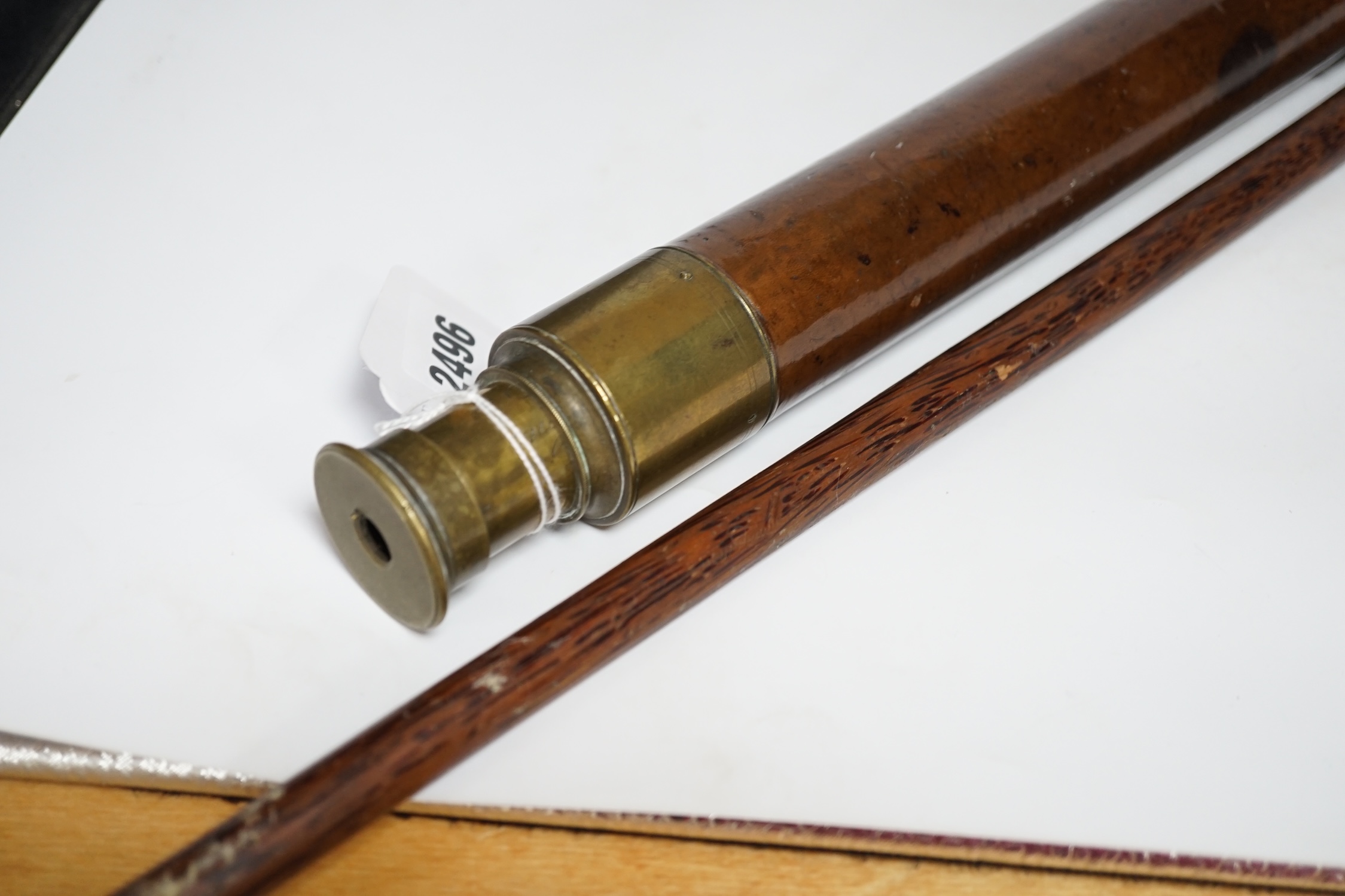 An inscribed cocus wood walking stick with carved handle in the form of a hand, ‘Pitcairn Island’ and a brass mounted two drawer telescope, largest 92cm in length
